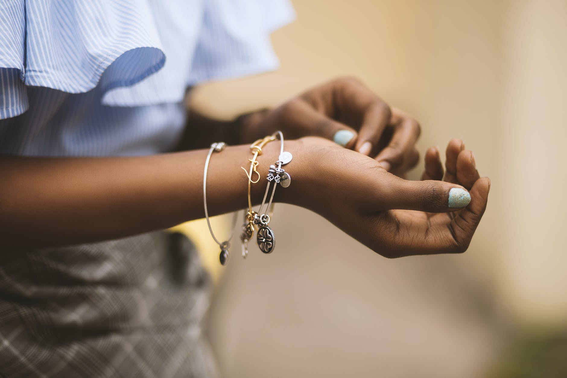 selective focus photography of person wearing three bangles