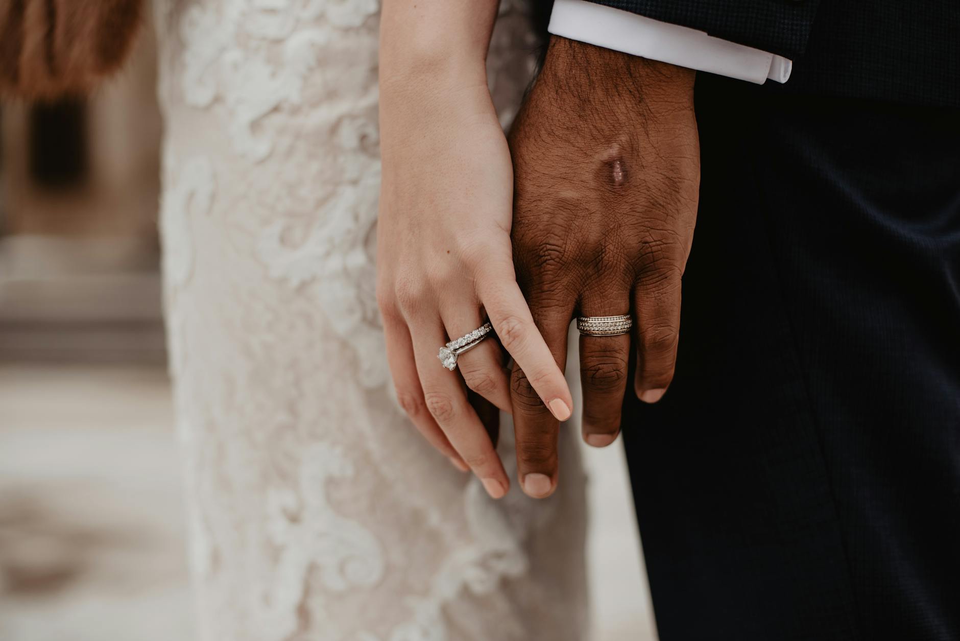 two persons wearing silver colored rings